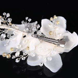 Handmade bridal hair clip with white fabric flowers and sparkling crystal beads on black background