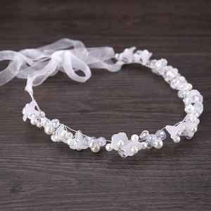 Vue détaillée d'un bandeau de mariée avec fleurs en tissu blanc et perles de cristal