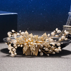 Golden bridal hair comb with elegant white pearls and rhinestones in a leaf design