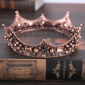 Macro detail of Baroque bronze crown with black gemstones and pearls on a book