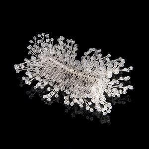 Close-up of handmade bridal hair comb with silver wire and sparkling faceted crystals