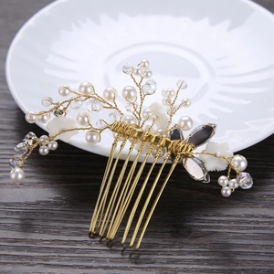 Detail of handmade bridal hair comb with gold wire, pearls, crystals and resin flowers