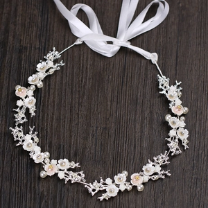 Serre-tête de mariée élégant avec fleurs en nacre, strass et perles sur fond bois sombre