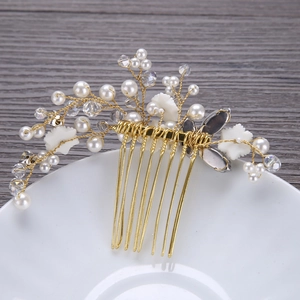 Detail of bridal hair comb with gold wires, white pearls, crystals and flower petals