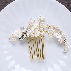 Detail of handmade bridal hair comb with gold floral patterns and white pearls