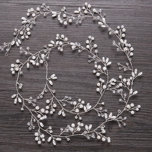 Dettaglio di un tralcio per capelli da sposa con perle bianche e cristalli su filo d'argento