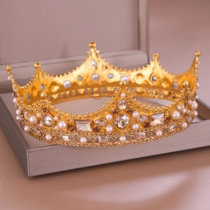Baroque gold crown with white pearls and clear crystals on a jewelry box