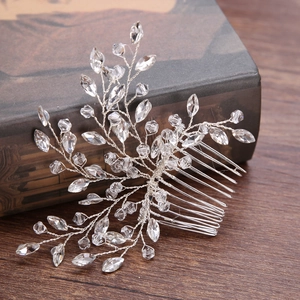 Detailed macro view of handmade crystal bridal hair comb with silver leaf-shaped wiring