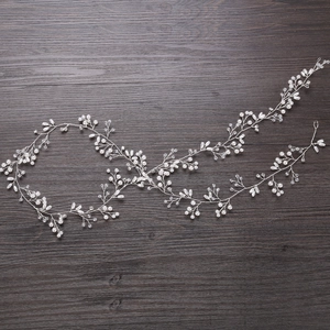 Dettaglio di accessorio per capelli fatto a mano con perle bianche e cristalli
