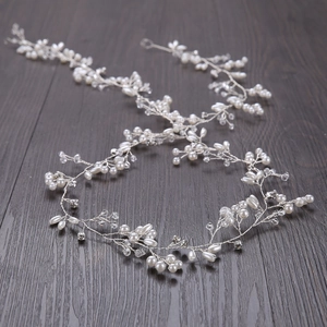 Dettaglio di tralcio per capelli da sposa fatto a mano con perle bianche e cristalli su filo