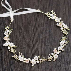 Détail du bandeau de mariée avec fleurs de nacre, perles blanches et strass dorés