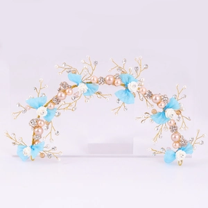 Dettaglio di tralcio per capelli sposa con perle rosa, fiocchi blu e fiori fatti a mano