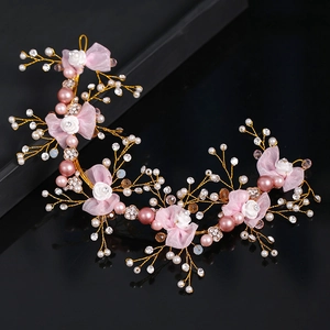 Dettaglio fascia da sposa fatta a mano con perle rosa, cristalli e fiori in tessuto