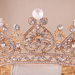 Macro shot of gold bridal crown showing heart patterns and clear rhinestone inlay details