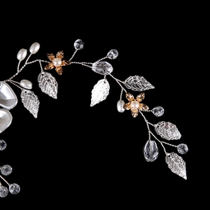 Dettaglio di accessorio per capelli da sposa fatto a mano con perle, cristalli e foglie