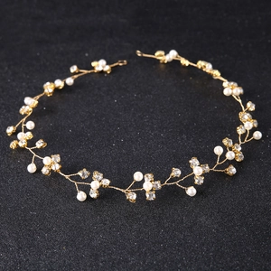 Close-up of golden bridal headband with white pearls and sparkling rhinestones