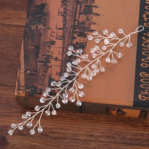 Elegant silver bridal hair vine with sparkling crystal beads on a vintage book background