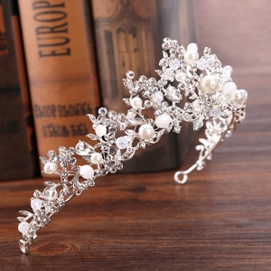 Silver bridal crown with branches, pearls, and crystals on a vintage book background