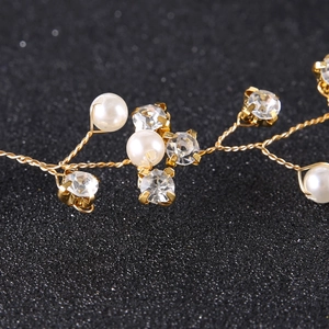 Detailed macro view of handmade bridal headband with gold wire, pearls, and crystals