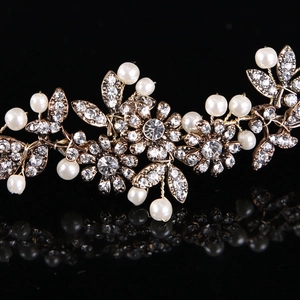 Detailansicht von goldenem Braut-Haarschmuck mit Kristallblumen und weißen Perlen