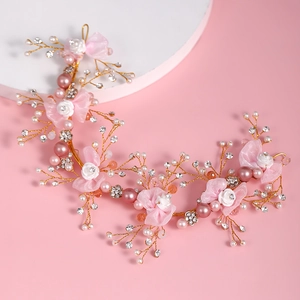 Dettaglio fascia da sposa con fiocchi in chiffon rosa, rose bianche e perle lucide