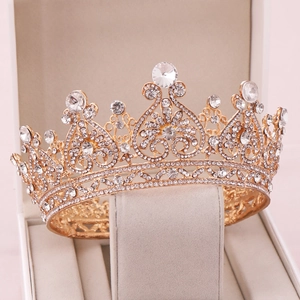 Macro view of golden rhinestone bridal crown with heart pattern in a beige velvet gift box