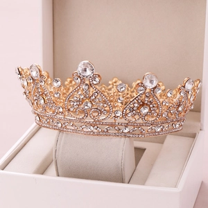 Detailed close-up of golden bridal tiara with rhinestones in a white gift box