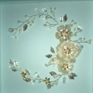 Dettaglio di fascia da sposa artigianale con fiori di resina, perle e foglie d'argento