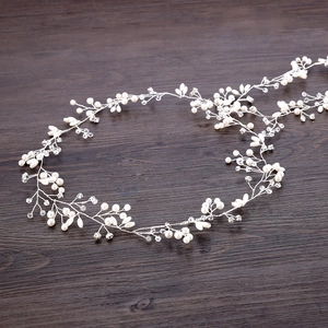 Dettaglio dell'accessorio per capelli da sposa in filo d'argento, perle e cristalli
