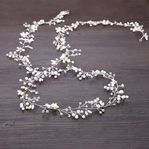 Dettaglio di tralcio per capelli da sposa fatto a mano con perle e cristalli su legno