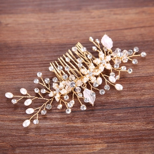 Elegant bridal hair comb with pearls, crystals and gold leaves on dark wood background