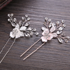 Silver and rose gold bridal hair pins with rhinestones and crystals on wood background