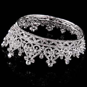 Macro detail of bridal crown featuring silver heart patterns and hanging water drop rhinestones