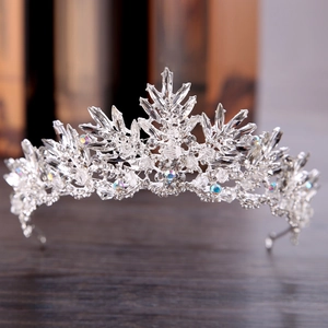 Eleganter silberner Braut-Tiara mit Blatt-Kristallen und AB-Steinen auf Holzuntergrund