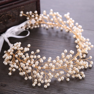 Handmade golden bridal hairband with white pearls and satin ribbons for weddings