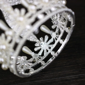 Macro shot of silver bridal crown featuring pearls and intricate baroque metalwork