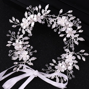 Silver bridal headband with handmade flowers, pearls, and crystals on a black background