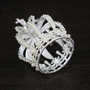 Detailed view of silver bridal crown featuring pearls and intricate crystal floral patterns