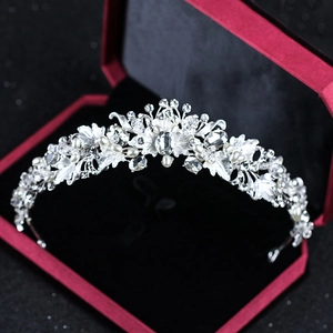 Detailed macro view of silver bridal crown with white pearls and crystals in a velvet box
