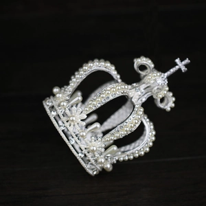 Macro detail of bridal crown featuring silver metal crosses, pearls and rhinestones