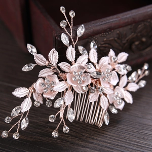 Rose gold leaf and flower bridal hair comb with shimmering crystals on dark wood