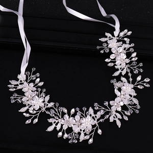 Handmade bridal leaf hairband with white flowers, pearls and crystals on black background