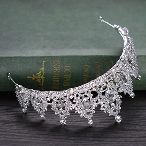 Detailed view of a silver bridal tiara with teardrop crystals on a vintage book