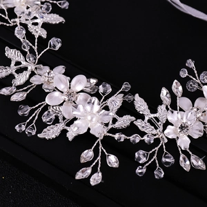 Elegant bridal hair vine with silver leaves, white flowers and crystals on black background