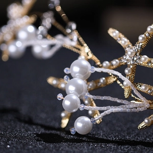 Detailaufnahme von goldenem Seestern-Haarschmuck mit Perlen und Kristallen für die Braut