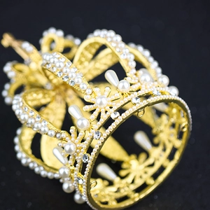 Close-up of golden pearl tiara with intricate metalwork and sparkling rhinestones
