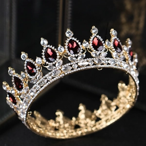 Détail macro d'une couronne dorée ornée de gemmes rouges en poire et strass en cristal