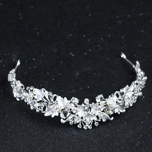 Detailed macro view of silver bridal tiara featuring leaf motifs, rhinestones and small pearls