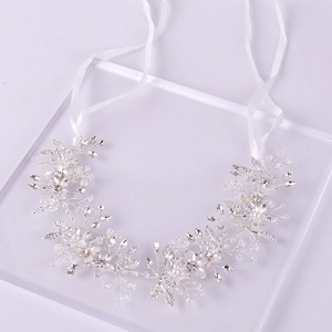Macro detail of bridal hair vine with silver leaf wire, white pearls and crystal flowers