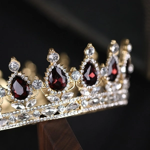Gros plan détaillé d'une couronne royale avec strass rouge foncé et base dorée luxueuse